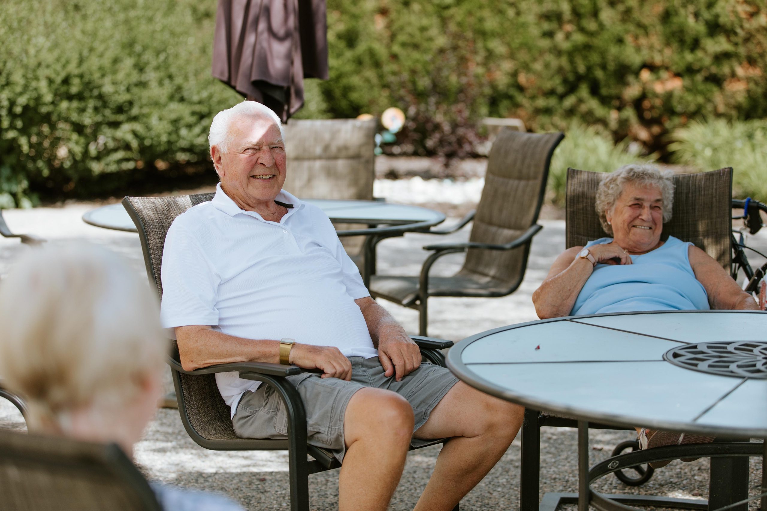 Several seniors enjoying the sun on the patio